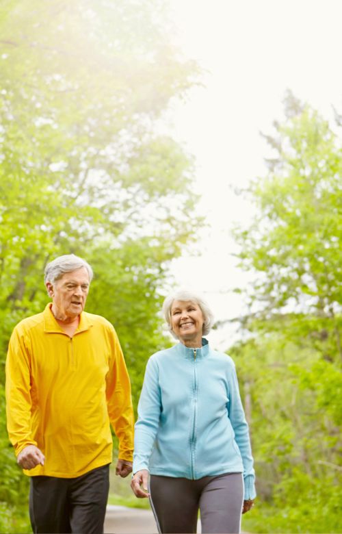 happy couple walking in the woods with healthy legs